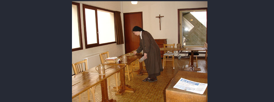 soeur qui prépare les tables du refectoire